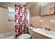 Standard bathroom with a shower-tub combo with colorful curtain, white sink, toilet, and matching pink tile at 2155 Nw 27Th Ave, Ocala, FL 34475