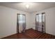 A simple bedroom with neutral walls, tiled floors, and a metal bed frame facing two windows with curtains at 2155 Nw 27Th Ave, Ocala, FL 34475