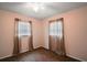 Cozy bedroom with hardwood-style floors, neutral-toned walls, and two windows dressed with flowing curtains at 2155 Nw 27Th Ave, Ocala, FL 34475
