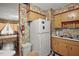 A full kitchen with a white refrigerator, yellow cabinets, floral wallpaper, and a view into the dining area at 2155 Nw 27Th Ave, Ocala, FL 34475