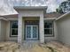 Inviting front entrance featuring double doors and a stone facade, enhancing curb appeal at 2283 Sw 140Th Ct, Ocala, FL 34481