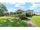 Landscaped backyard with a brick walkway leading to a charming home with lush green grass at 3515 Ne 43Rd Pl, Ocala, FL 34479