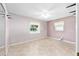 A bedroom showcasing neutral walls, tile flooring, and two windows at 3515 Ne 43Rd Pl, Ocala, FL 34479