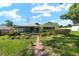 Inviting single-story home with a screened porch, complemented by a brick path and landscaped garden at 3515 Ne 43Rd Pl, Ocala, FL 34479