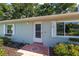Charming home entrance with painted brick, complemented by decorative flower boxes and a glass storm door at 3515 Ne 43Rd Pl, Ocala, FL 34479
