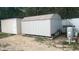 Backyard view of storage sheds with access to water features and white privacy fence at 43 Pine Run, Ocala, FL 34472
