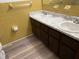 A bathroom featuring double sinks, a white marbled countertop, and brown cabinets for storage at 4701 Ne 9Th St, Ocala, FL 34470