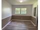 Neutral dining room with wainscotting, new floors, and bright natural light from the large window at 4701 Ne 9Th St, Ocala, FL 34470
