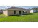 Back exterior view of home that shows a quaint back patio and lawn at 51 Pine Trace Loop, Ocala, FL 34472