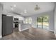 Modern open-concept kitchen featuring stainless steel appliances, granite countertops, and a sliding door to back patio at 51 Pine Trace Loop, Ocala, FL 34472
