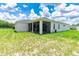 Back exterior view of home, with a screened lanai and green lawn at 5239 Sw 114Th Street Rd, Ocala, FL 34476