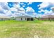 Expansive backyard with lush lawn, and views of the screened lanai and surrounding greenery at 5239 Sw 114Th Street Rd, Ocala, FL 34476