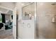 Bathroom shower featuring tiled walls, glass doors, and built-in storage shelves at 5239 Sw 114Th Street Rd, Ocala, FL 34476