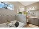 Bright bathroom features a soaking tub, double vanity, and a decorative mosaic tile backsplash at 5239 Sw 114Th Street Rd, Ocala, FL 34476