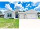 Charming single-story home with a well-manicured lawn, a two-car garage, and modern architectural details at 5239 Sw 114Th Street Rd, Ocala, FL 34476