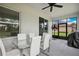 A bright lanai with contemporary glass top dining table and six chairs, overlooking the backyard at 5239 Sw 114Th Street Rd, Ocala, FL 34476