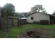 Property's backyard featuring a fire pit, wooden fence, and a gate at 6141 Nw 64Th Ct, Ocala, FL 34482