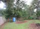 Backyard with a wooden fence, blue water tank, and lush greenery at 6141 Nw 64Th Ct, Ocala, FL 34482