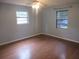 Well-lit bedroom boasts hardwood floors, two windows, and neutral wall paint at 6141 Nw 64Th Ct, Ocala, FL 34482