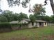 Property's exterior with stone accents surrounded by a wooden fence and mature trees at 6141 Nw 64Th Ct, Ocala, FL 34482