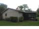 Rear exterior view with screen porch and garden area surrounded by greenery at 6141 Nw 64Th Ct, Ocala, FL 34482