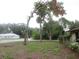 Side yard view of the property showing the lot and surrounding trees at 6141 Nw 64Th Ct, Ocala, FL 34482