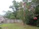 Flowering tree in property's side yard, surrounded by a wooden fence and trees at 6141 Nw 64Th Ct, Ocala, FL 34482