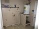 A small utility room with a water heater, storage shelf, and tile flooring at 6141 Nw 64Th Ct, Ocala, FL 34482