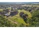 Aerial view of the horse farm showing multiple pastures, barns, and paddocks surrounded by mature trees at 7563 Nw 21St St, Ocala, FL 34482