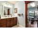 Bathroom featuring a wood vanity, tile floors, and a window overlooking the property at 7563 Nw 21St St, Ocala, FL 34482