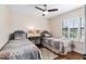 Cozy bedroom showcasing twin beds, hardwood floors, and a window with plantation shutters at 7563 Nw 21St St, Ocala, FL 34482