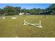 Wide shot of fenced equestrian arena with horse jumps in place on bright green grass at 7563 Nw 21St St, Ocala, FL 34482