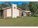 Exterior view of home featuring brick facade, metal roof, a statement star and manicured lawn at 7563 Nw 21St St, Ocala, FL 34482