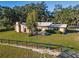 Charming single-story brick home with a metal roof, lush landscaping, and a spacious front yard at 7563 Nw 21St St, Ocala, FL 34482