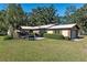 A well-maintained home with manicured lawn, a patio area, and mature shrubs enhances its curb appeal at 7563 Nw 21St St, Ocala, FL 34482