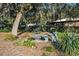 Secluded garden area with mature trees, picnic table, and bird bath fixtures, offering a tranquil outdoor space at 7563 Nw 21St St, Ocala, FL 34482