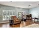 Comfortable living room with hardwood floors, a leather recliner, and natural light from shuttered windows at 7563 Nw 21St St, Ocala, FL 34482