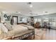 Open-concept main bedroom with hardwood floors, soft blue walls, and a wrought iron bed frame at 7563 Nw 21St St, Ocala, FL 34482