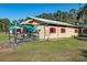 Tan and red outbuilding with red shutters, showcasing ample space for storage and various activities at 7563 Nw 21St St, Ocala, FL 34482