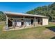 Exterior view of outbuilding structure with open stalls and storage options, set on a grassy lawn at 7563 Nw 21St St, Ocala, FL 34482
