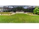 Beautifully landscaped backyard featuring a screened pool and lush, green lawn at 7814 Sw 97Th Cir, Ocala, FL 34481