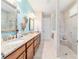 Bright bathroom featuring double sinks, granite countertops, and a spacious tiled shower at 7814 Sw 97Th Cir, Ocala, FL 34481