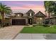 Charming home featuring a well-manicured lawn, brick driveway and two-car garage at dusk at 7814 Sw 97Th Cir, Ocala, FL 34481