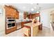 Open-concept kitchen featuring stainless steel appliances, granite countertops, and dark wood cabinets at 7814 Sw 97Th Cir, Ocala, FL 34481