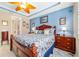 Main bedroom with blue accent wall, tray ceiling, ceiling fan, tiled floor, and ensuite bathroom at 7814 Sw 97Th Cir, Ocala, FL 34481