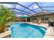 Beautiful screened pool featuring a waterfall, lounge chairs and a grill for outdoor enjoyment at 7814 Sw 97Th Cir, Ocala, FL 34481