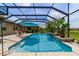 Screened pool with waterfall feature, lush landscaping, lounge chairs for sunny relaxation at 7814 Sw 97Th Cir, Ocala, FL 34481