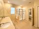 Bright bathroom featuring double sinks with a glass enclosed walk-in shower, tile floors, and a window at 8303 Sw 78Th Cir, Ocala, FL 34476