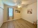 Bright bedroom with wood flooring features a ceiling fan, closet, and a large window at 8303 Sw 78Th Cir, Ocala, FL 34476