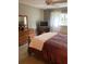 Bedroom with hardwood floors, large dresser, queen bed and TV with large bright window at 8450 Sw 90Th St # D, Ocala, FL 34481